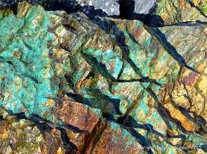 Blue-green copper minerals in cliff rocks at Porth Kidney in Cornwall, England