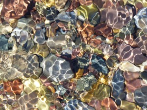 Coloured pebbles under water on a sunny day