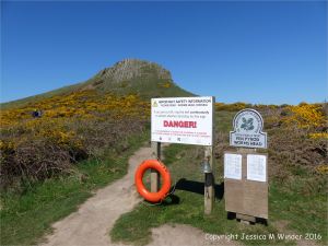 Signs and life belt on Worm's Head Island in Gower, South Wales.