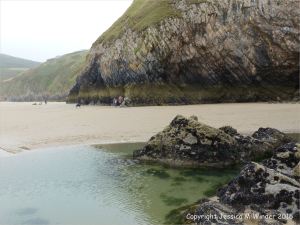 Tide pool and wet sand at low tide on Rhossili beach
