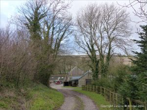 English countryside view of country lane leading to farm outbuildings