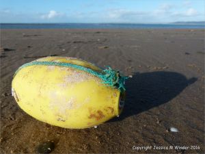 Flotsam yellow plastic fishing net float