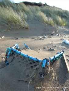 Blue plastic crate flotsam on sandy beach