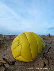 Yellow plastic football washed ashore as flotsam