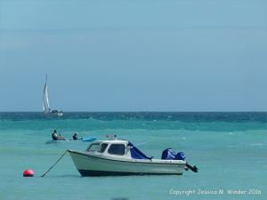 Leisure craft on the banded blue waters off the Dorset Coast, England.