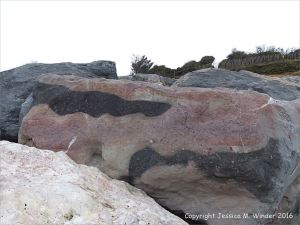 Natural pattern in a rip-rap boulder at Seatown, Dorset, England.