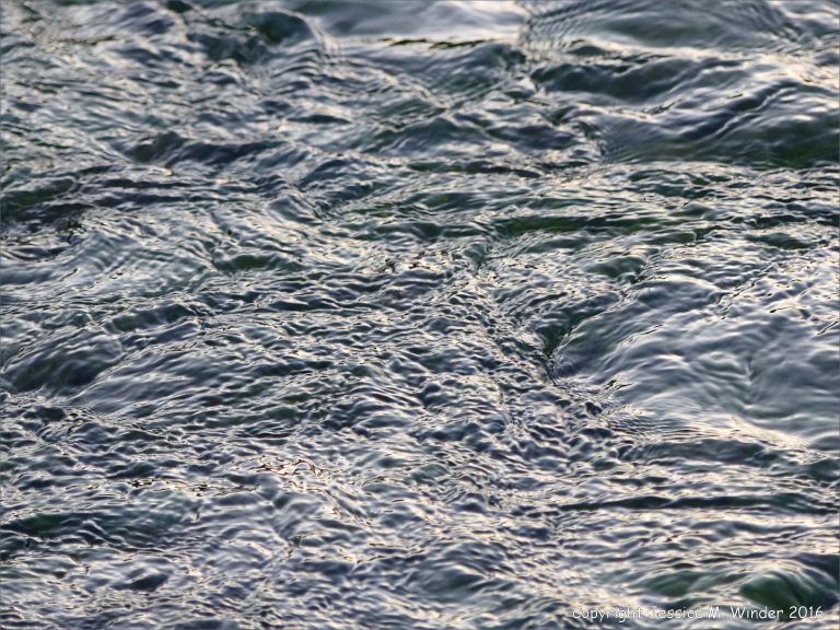 Dark swirling waters of a river at dusk