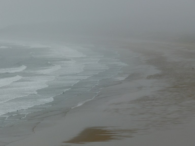 Five people on the sandy beach at Rhossili