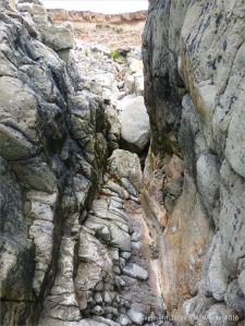Gully of water-worn limestone rock layers on the Worms Head Causeway in Gower, South Wales.