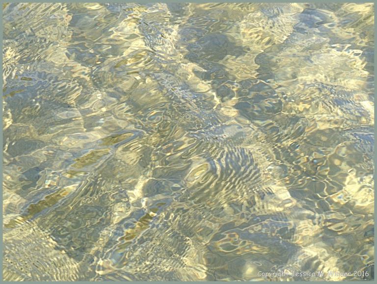 Water surface texture patterns in a tide pool on sand