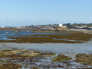 View looking over rocks towards Fort Grey at Rocquaine Bay on Guernsey