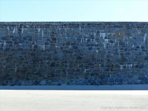 Sea wall of local stone at the southern end of Rocquaine Bay in Guernsey