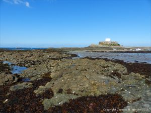 View over rocks to Fort Grey at Rocquaine Bay