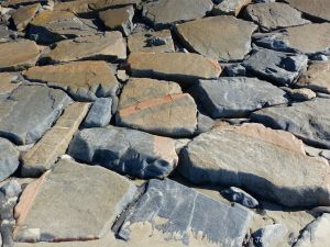Stone slabs at the base of the sea wall at Rocquaine bay