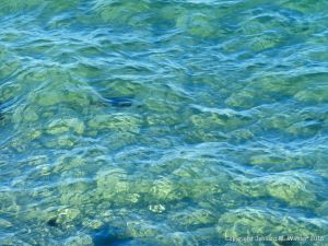 Texture and pattern of blue sea water over a yellow sandy shore