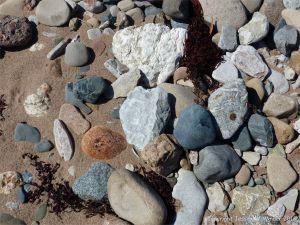 Assorted beach stones on the shore at Crystal Cliffs Beach