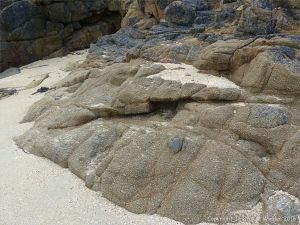 Rocky outcrop with a hollow filled by coarse shell sand on Herm