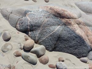 Rock outcrop in the sand at Black Brook Cove