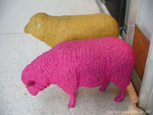Two life-sized models of sheep at a railway station