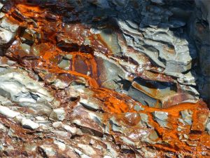 Iron-stained water running down cliff strata