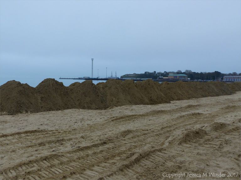 Piles of imported sand on Weymouth Beach