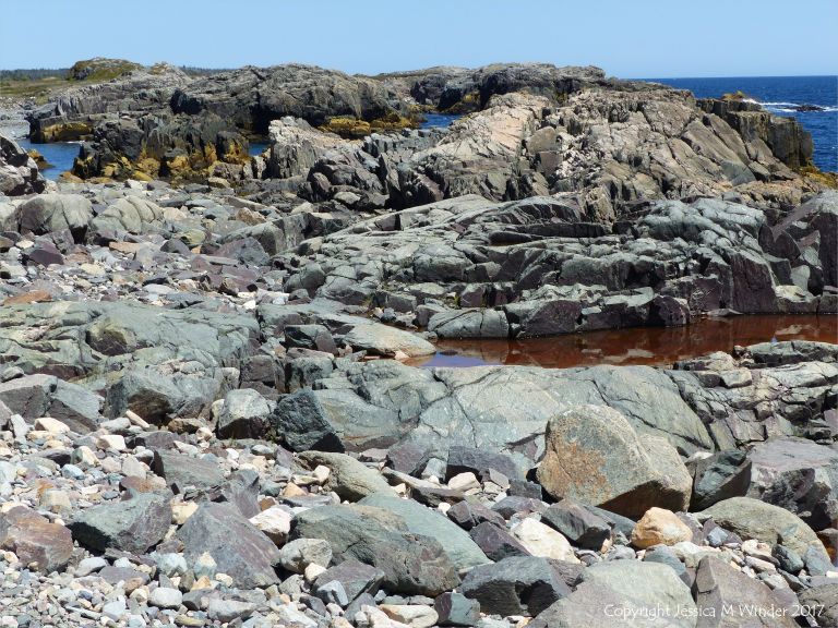 The shoreline with rocks of pyroclastic breccia north of Louisbourg Lighthouse in Cape Breton in Nova Scotia