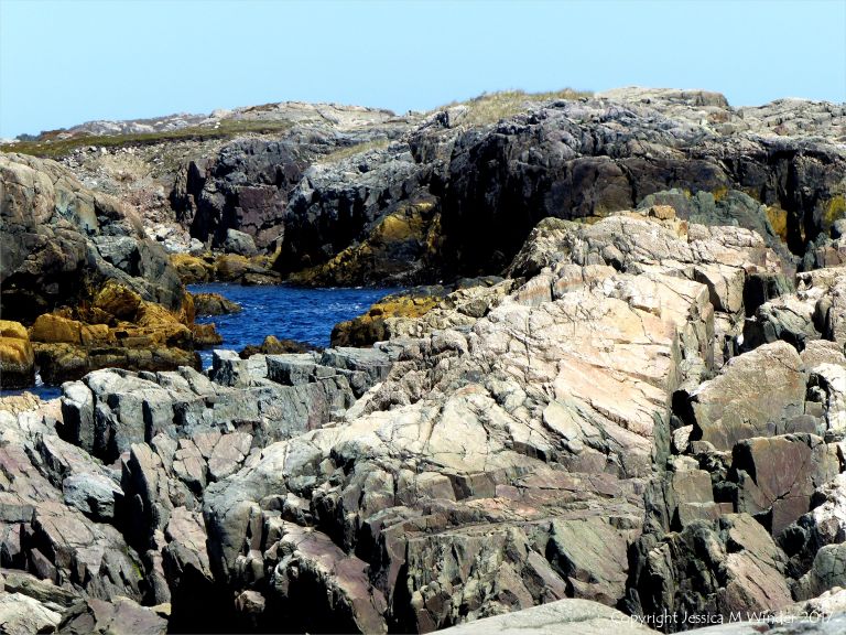 The shoreline with rocks of pyroclastic breccia north of Louisbourg Lighthouse in Cape Breton in Nova Scotia