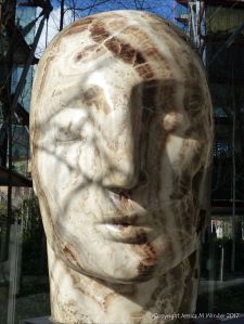 Carved stone head by Emily Young displayed at Neo Bankside in London