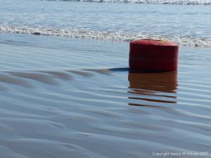 Stranded mooring buoy about to be covered by the waves again