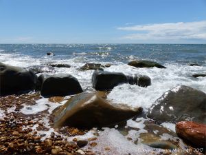Boulders in the waves of the ebbing tide at Seatown in Dorset