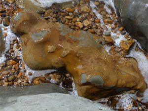Beach boulder splashed by waves