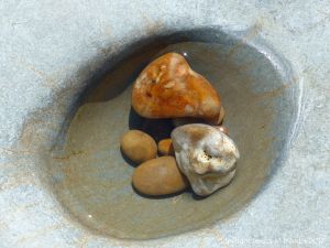 Pebbles in a water-filled smooth rock hollow