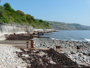 Old wooden breakwaters with rusty iron fittings on the sea shore