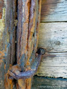 Rusty iron upright on an old wooden breakwater