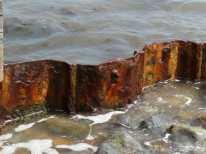 Rusting ironwork support from a delapidated breakwater