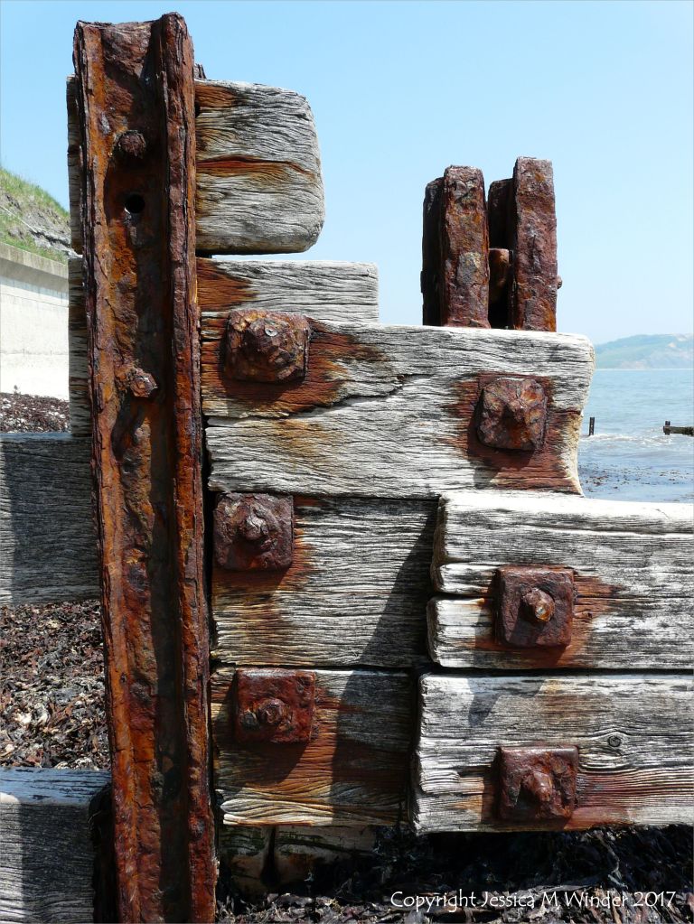 Rusting ironwork on a wooden breakwater