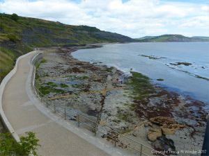 View looking down on the rocky shore below the new sea wall walkway at Lyme Regis