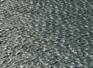 Silvery natural pattern and texture on the surface of water ruffled by a strong breeze