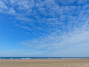 Rhossili Beach on a summer day showing big blue sky