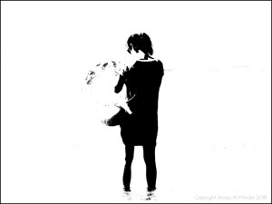 Black and white image of a woman holding an inflatable swim ring on the beach