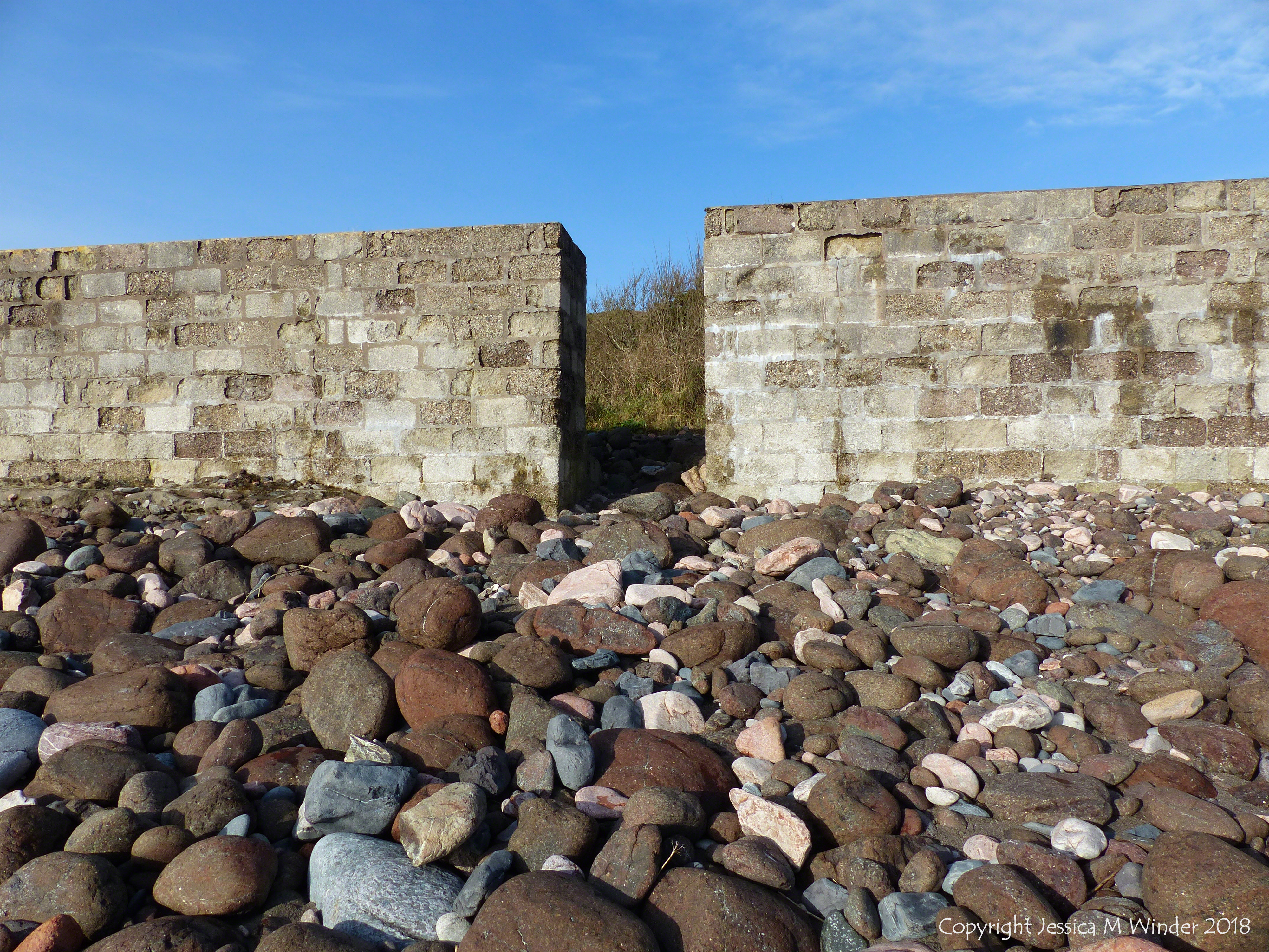Sea wall and beach boulders at Kennack Sands