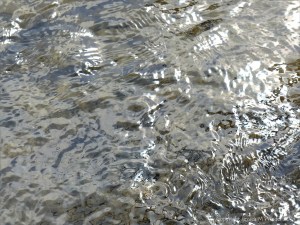 Silvery natural patterns on the surface of flowing water