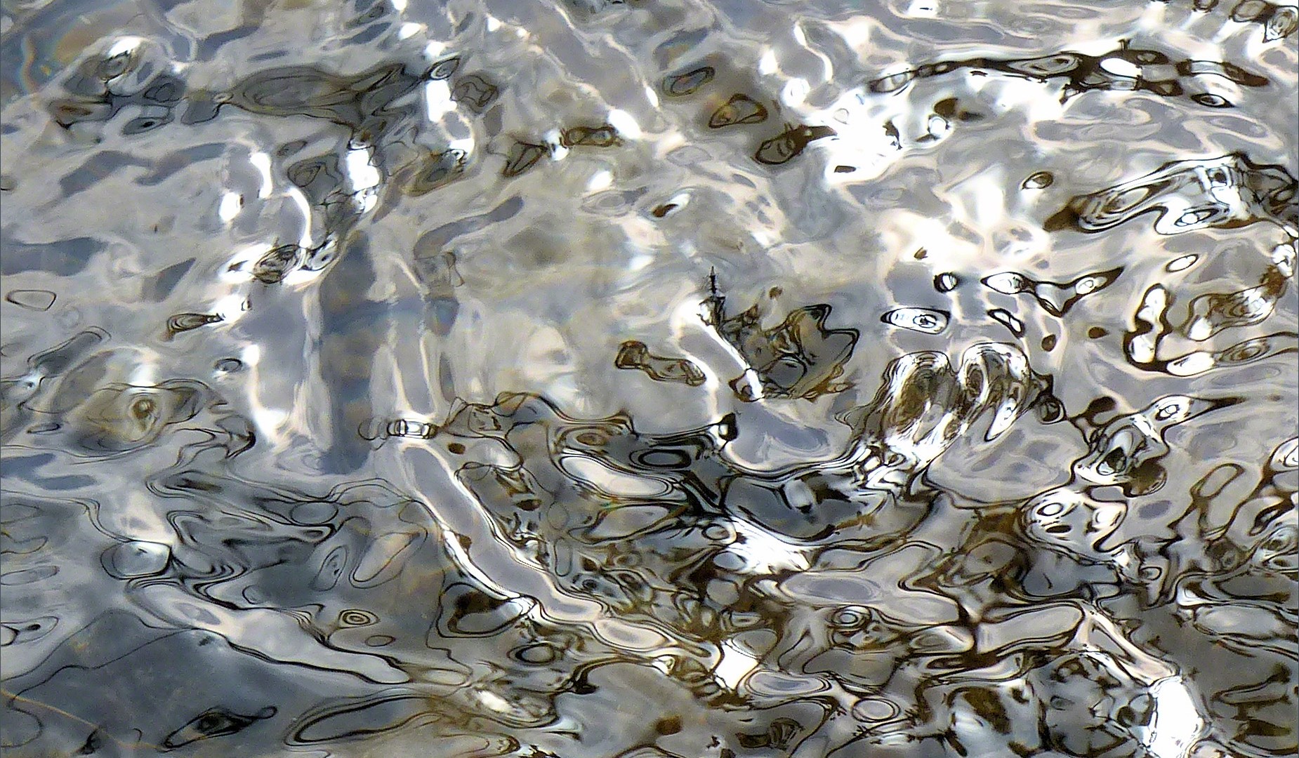 Silvery natural patterns on the surface of flowing water