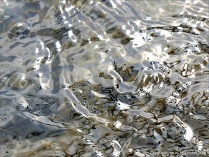 Silvery natural patterns on the surface of flowing water