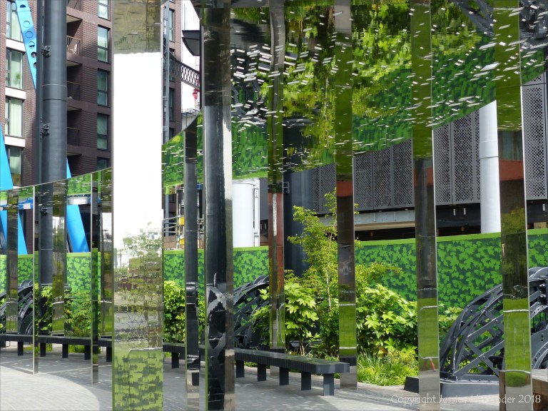 A circular mirrored garden in the structural framework of an old gasometer