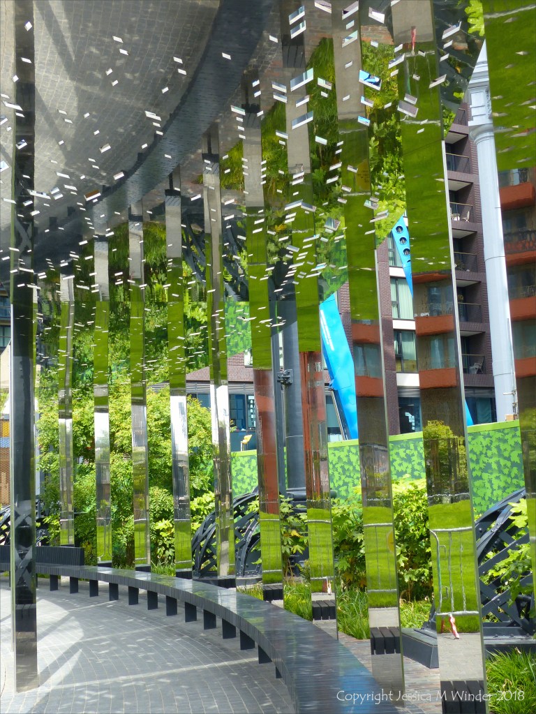 A circular mirrored garden in the structural framework of an old gasometer