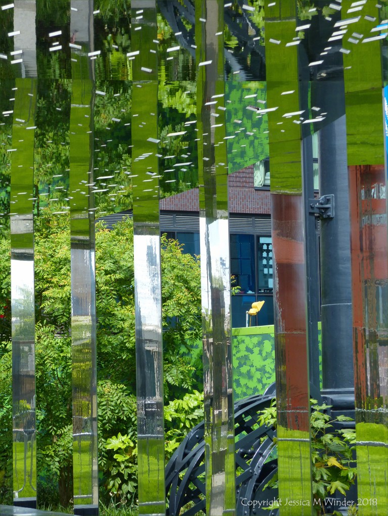 A circular mirrored garden in the structural framework of an old gasometer