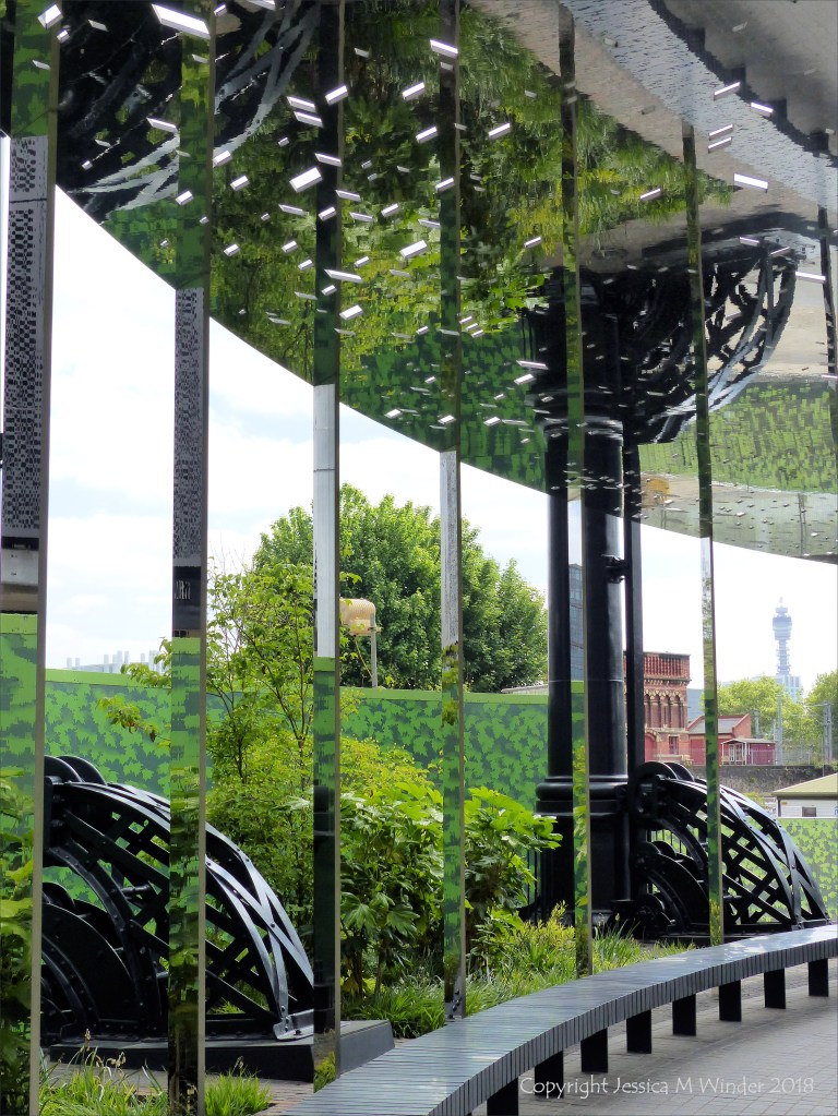 A circular mirrored garden in the structural framework of an old gasometer