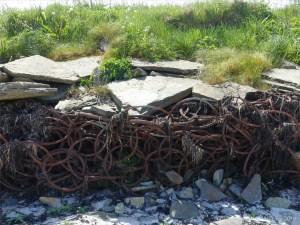 Sea defence structure of rusty iron rings at Grit Ness