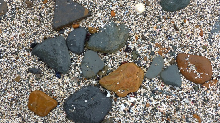 Beach stones and shell sand at Birsay causeway